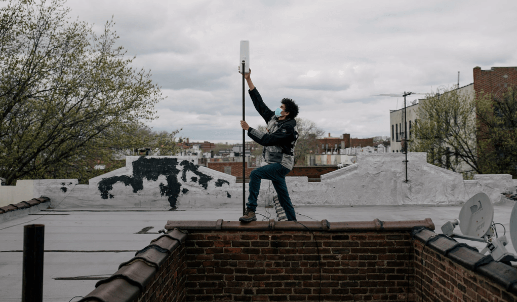 Daniel Heredia working this spring to bring inexpensive Wi-Fi to a building in Brownsville, Brooklyn.Credit...Jose A. Alvarado Jr. for The New York Times