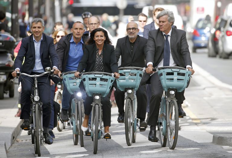 In Europe, they get e-bikes: Here is Paris Mayor Anne Hidalgo on an e-bike in a bike lane. Chesnot/ Getty Images